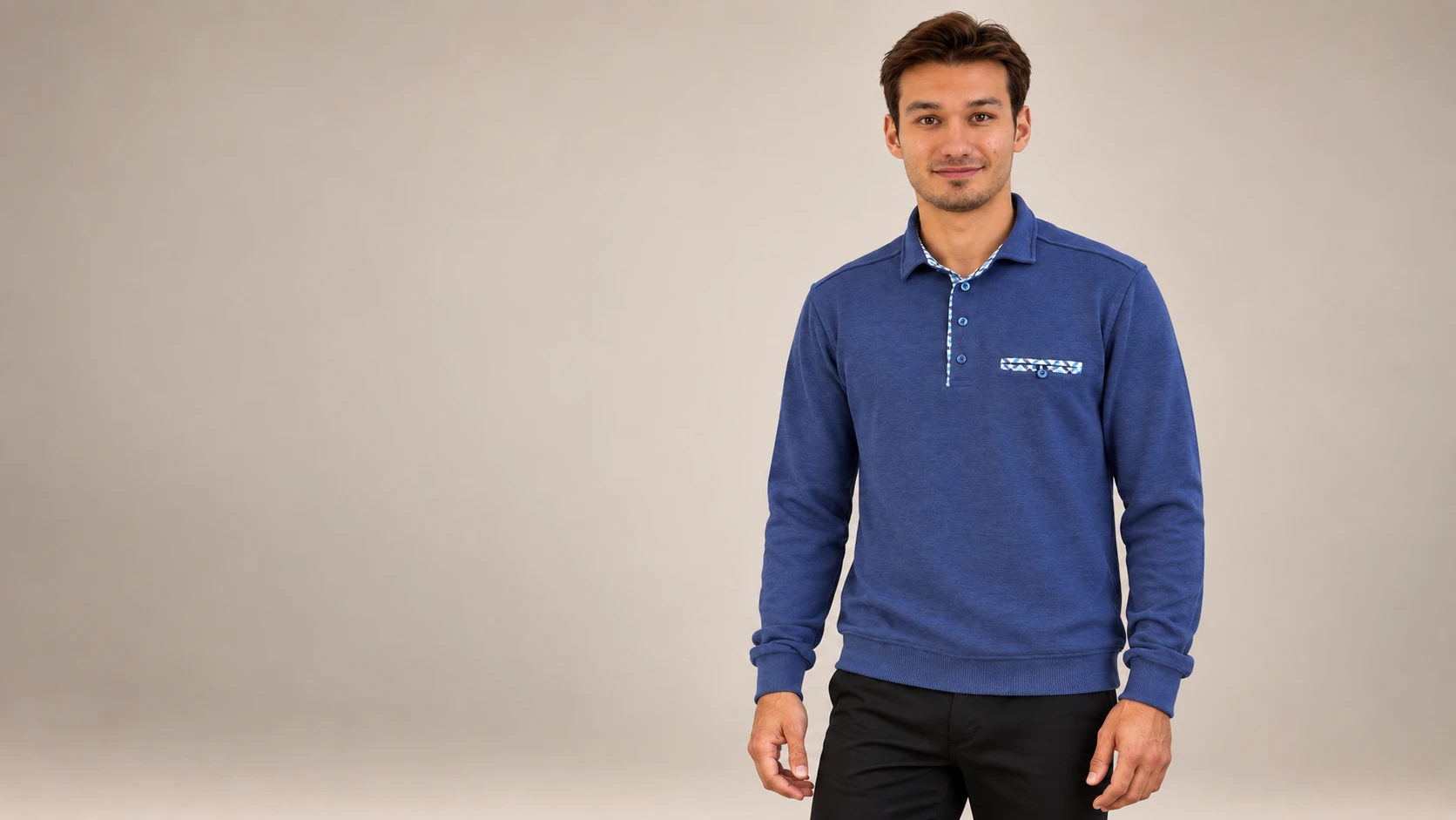 Polo bleu à manches longues et détails à motifs porté en studio